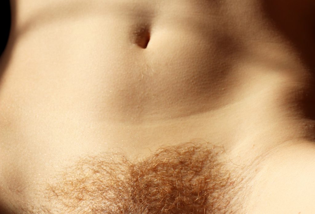 Man sieht den nackten Bauch der Sexarbeiterin Lillia Rubin. Die Haut ist sonnenbeschienen. Am unteren Rand ist der Ansatz der Intimbehaarung zu sehen der im Januhairy gewachsen ist.